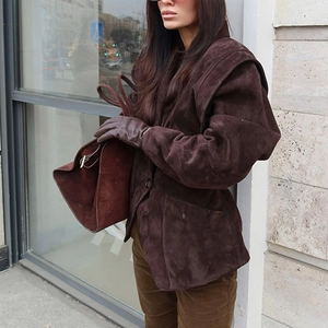 Detailed texture of dark brown suede jacket with large side pockets and soft finish
