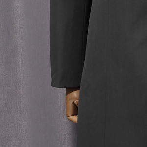 Close-up of high-quality dark grey suit sleeve showing dense plain weave fabric texture