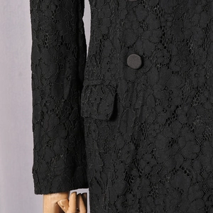Detail of floral lace blazer with fabric buttons and flap pockets in black