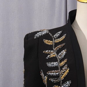 Macro detail of luxury black blazer showing intricate silver beadwork and sequin embroidery