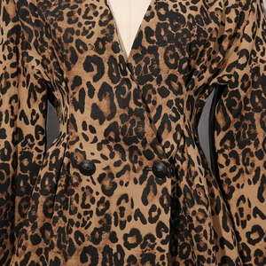 Détail d'un blazer léopard avec col en V et boutons métalliques à motif lion embossé