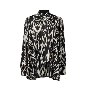 Detailed view of the bow-tie neckline and monochrome abstract print on long-sleeve shirt