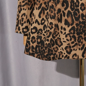 Vue détaillée du tissu imprimé léopard avec texture sergé sur un mannequin en bois