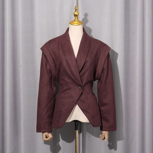 Detailed view of dark burgundy waist-cinched blazer with structured padded shoulders