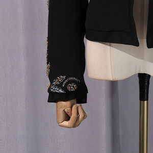 Close-up of exquisite beaded leaf embroidery and sequins on the black blazer sleeve