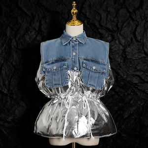 Dettaglio del gilet patchwork in denim e argento metallizzato con coulisse in vita