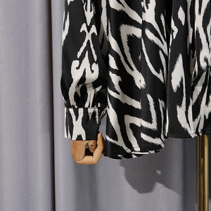 Detail of contrast geometric pattern shirt with cuffed sleeves and fine tailoring