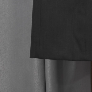 Detail of premium black suit fabric featuring precise stitching and smooth texture