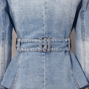 Detail view of denim jacket waist with wide belt loops and peplum flared hem structure