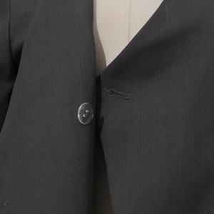 Detailed close-up of high-quality twill fabric and resin button on women suit jacket