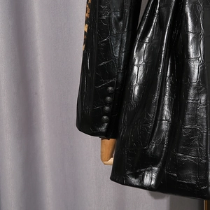 Détail de veste en similicuir crocodile avec imprimé léopard et boutons aux poignets