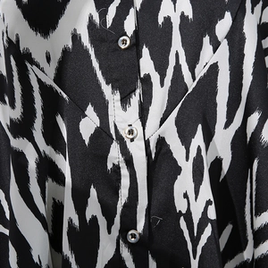 Detailed view of Ikat-style wave print and pearlescent buttons on a contrast shirt