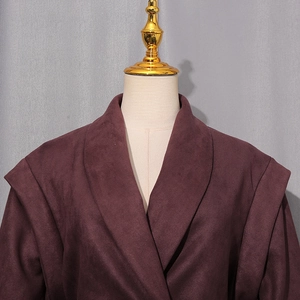 Detailed view of dark burgundy faux suede jacket featuring large lapels and layered shoulder design
