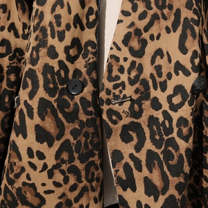 Gros plan sur la texture léopard et un bouton rond noir sur la veste de costume