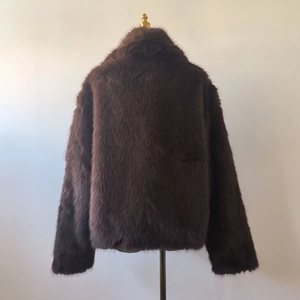 Detailed back view of a dark brown faux fur coat with thick texture and lapel collar