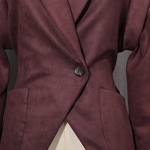 Detail view of burgundy suede blazer featuring classic lapels and a single resin button