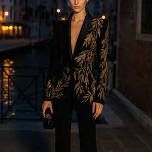 Détails de broderie dorée sur blazer en velours noir avec col châle en satin
