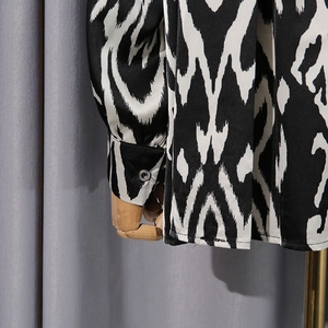 Detail of contrast geometric print on silky long-sleeved shirt with button cuff