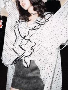 Polka dot ruffle blouse with chic grey mini skirt featuring metallic stud details