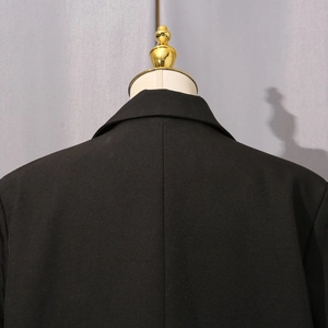 Detail of the back shoulder and collar seam on a slim-fit black formal blazer
