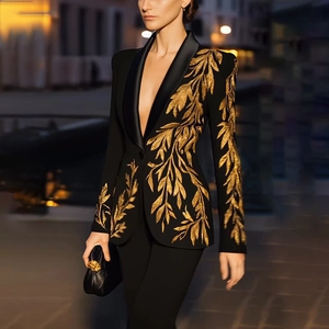 Vue détaillée de la broderie dorée sur un blazer noir cintré avec revers en satin