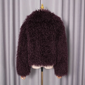 Detail of deep purple faux fur jacket showing thick curly texture and plush material