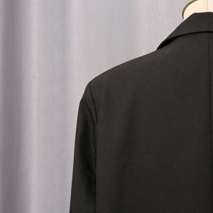 Detailed view of black slim fit blazer showing fine fabric texture and premium stitching