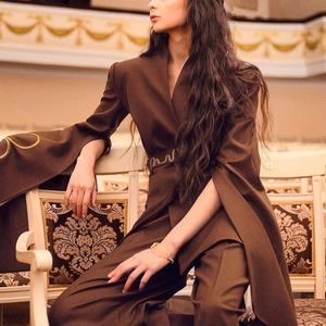 Detail of dark brown blazer with embroidered belt and flared split sleeves in elegant setting