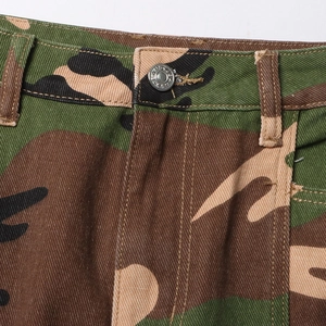 Detail of camouflage skirt waist with metal button and textured twill fabric design