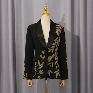 Détails de broderie de feuilles dorées sur blazer noir avec revers satiné et coupe ajustée