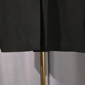 Close-up of black blazer hem showing premium fabric texture and neat stitching details