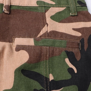Detailed view of camouflage mini skirt featuring heavy stitching and durable twill fabric