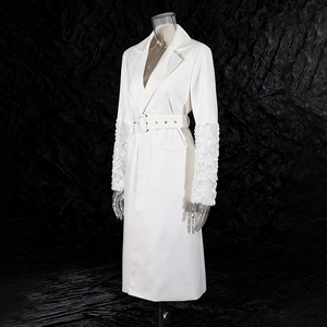 Détail de robe trench blanche élégante avec poignets à fleurs 3D et ceinture assortie
