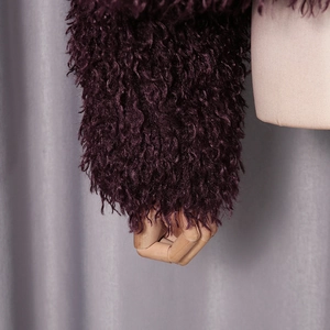 Detail view of deep purple faux fur sleeve showing luxury wavy texture and soft plush fabric