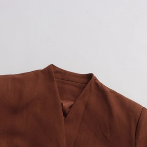 Detail of caramel blazer neck with V-neck cut, smooth lining and fine fabric texture