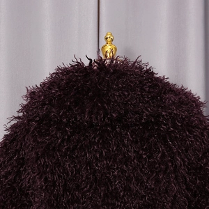 Close-up of deep purple faux fur texture with fluffy curled fibers on a display stand
