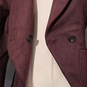 Detail of dark burgundy suede jacket featuring marble texture buttons and large lapels