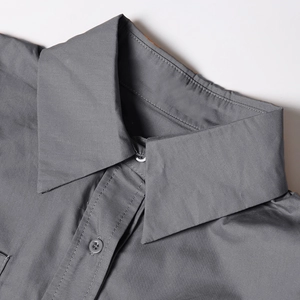 Close-up of the elegant pointed collar and tonal buttons on this dark gray sleeveless shirt