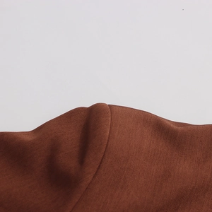 Detailed macro view of brown twill fabric texture and stitching on women blazer sleeve