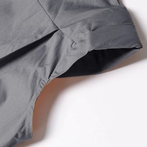 Close-up of fine stitching on dark grey sleeveless shirt with contrast orange lining