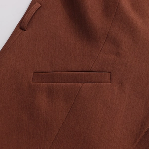 Detailed close-up of dark reddish-brown twill fabric texture and fine stitching on blazer