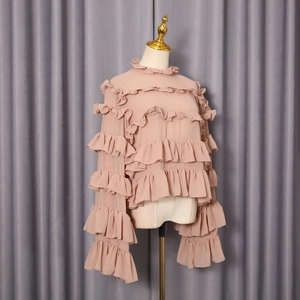Detail of multi-layered ruffles and stand collar on dusty pink chiffon blouse