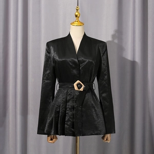 Détail du blazer en satin noir avec ourlet plissé et ceinture à boucle métallique