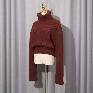 Vue détaillée du pull bordeaux à col roulé avec maille épaisse et poignets repliés