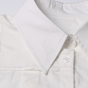 Dettaglio del colletto della camicia bianca con cuciture rifinite e bottoni traslucidi