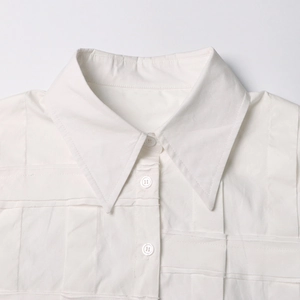 Primo piano di camicia bianca in cotone con colletto classico e dettagli plissettati 3D