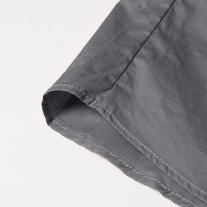 Close-up of the reinforced double stitching and textured fabric on the dark grey sleeveless shirt