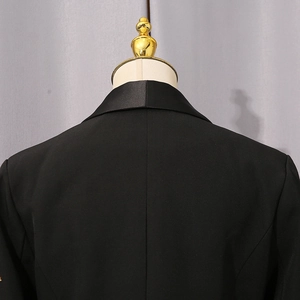 Vue détaillée du revers en satin et du tissu noir premium de ce blazer cintré