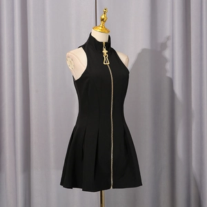 Detail shot of the front gold zipper and unique geometric puller on the black mini dress
