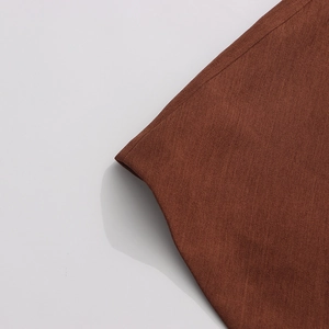Detail of premium brown textured fabric with fine stitching for professional women's blazer